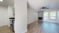 This single-story, 2-bedroom, 2-bathroom home offers a thoughtfully designed layout that maximizes every square foot of its compact footprint. Wood-look flooring flows consistently throughout all rooms, lending warmth and cohesion to the entire space. The combined living and dining area serves as the heart of the home, highlighted by a tile-surround fireplace, a ceiling fan, and natural light from a large window. The galley-style kitchen is well-equipped with stainless steel appliances, gray shaker-style cabinetry, dark stone countertops, and a bold geometric patterned tile backsplash. Both bathrooms are finished with large-format gray tile surrounds over tub-shower combos, gray vanity cabinetry, dark stone countertops, and ornate framed mirrors. The bedrooms are bright and comfortable, each featuring ceiling fans and windows with natural light. The primary bedroom includes access to a walk-in closet with dual shelving systems for generous storage. A dedicated laundry area adds everyday convenience. The neutral color palette of soft whites and grays throughout the home creates a clean, modern ambiance that is both functional and inviting.