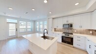 Located in Georgetown, TX, this thoughtfully designed single-story unit offers 1 bedroom and 2 full bathrooms within a well-organized floor plan. Light wood-look flooring flows consistently throughout, complementing the bright, neutral color palette that defines the space.

The kitchen serves as the centerpiece, boasting white shaker cabinetry with matte black hardware, a warm-toned tile backsplash, and a full suite of stainless steel appliances including a range, microwave, and refrigerator. A central island with a white quartz countertop and undermount sink anchors the open-concept layout, which extends seamlessly into a living area bathed in natural light from multiple windows.

The primary bedroom is a comfortable, well-proportioned retreat featuring a ceiling fan, natural light from blinds-fitted windows, and access to dedicated closet space. Both bathrooms are finished in a clean, modern style with white cabinetry, undermount sinks, matte black fixtures, and tiled tub-shower combinations. A built-in nook near the kitchen provides additional functional storage or workspace. Recessed lighting throughout enhances the bright, airy ambiance of this move-in-ready Georgetown residence.