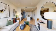 Located at 375 18th St NW in Atlanta, GA, this one-bedroom, one-bathroom residence offers a thoughtfully designed open-concept floor plan with contemporary finishes throughout. Light-toned hardwood-style flooring flows seamlessly through the combined kitchen and living area, creating a bright, cohesive feel anchored by recessed lighting overhead.

The kitchen is a standout feature, showcasing gray flat-front cabinetry with matte black hardware, white quartz countertops, a classic subway tile backsplash, and a full suite of stainless steel appliances including a gas range, microwave, and a large side-by-side refrigerator. A center island with a single-basin sink and bar seating provides additional prep space and a natural gathering point.

The bedroom is a comfortable, carpeted retreat bathed in natural light from oversized windows, with direct access to the walk-in closet. The full bathroom features a dual-sink vanity with gray cabinetry and white countertops, matte black fixtures, a glass-enclosed walk-in shower with white tile surround, and hardwood-style flooring. A dedicated laundry area with stacked units adds everyday convenience. The private balcony completes this well-rounded Atlanta residence.