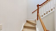 Located at 1900 Barclay Blvd in Princeton, NJ, this well-appointed two-story home offers 2 bedrooms and 3 bathrooms across a thoughtfully designed layout. The main level hosts an open-concept living, dining, and kitchen area filled with natural light from large windows and sliding glass doors that open to outdoor greenery. The kitchen is equipped with stainless steel appliances, warm wood cabinetry, granite countertops with a central island, and stylish pendant lighting. The living room features vaulted ceilings, a ceiling fan, a cozy fireplace with a built-in niche above, and generous windows that bathe the space in sunlight. The dining area is accented by a modern gold-toned chandelier. Upstairs, the spacious primary bedroom impresses with soaring vaulted ceilings, multiple windows, a ceiling fan, a walk-in closet with built-in shelving, and a private en-suite bathroom. The second bedroom offers ample room with its own closet and natural light. Additional highlights include a carpeted staircase with a classic wood-and-white baluster railing, a utility room, hallway, and an attached garage. Three full bathrooms, including one with a tub-shower combination, complete this comfortable Princeton residence.