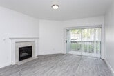 Located in Millcreek, Utah, this single-floor, 2-bedroom, 2-bathroom residence offers a thoughtfully designed layout with clean finishes throughout. The open living room serves as the heart of the home, highlighted by a tile-surround fireplace with a classic white mantel and a full-width sliding glass door fitted with vertical blinds that invites natural light and provides access to an outdoor area. Light-toned luxury vinyl plank flooring flows consistently throughout the entire space, lending a cohesive, modern feel.

The kitchen is well-equipped with white shaker-style cabinetry, stainless steel appliances including a range, microwave, and refrigerator, a tile backsplash, and a generous peninsula featuring a double-basin sink and dark quartz-style countertops — ideal for both cooking and casual dining.

Both bedrooms offer comfortable proportions with ample natural light through blinds-fitted windows. The spacious primary bedroom includes access to a walk-in closet outfitted with wire shelving systems for organized storage. The bathrooms are finished with white vanity cabinetry, dark countertops, and brushed gold hardware accents. A dedicated in-unit laundry room accommodates a full-size washer and dryer. The overall palette of crisp whites and neutral tones creates a bright, clean, and inviting atmosphere throughout.