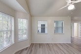 Located at 4545 S Panther Creek Drive in The Woodlands, TX, this 2-bedroom, 2-bathroom residence offers a thoughtfully designed single-floor layout. The living room is a standout space, featuring vaulted ceilings, a ceiling fan, and a charming bay window that floods the room with natural light and frames views of the surrounding greenery. Light-toned wood-look flooring extends throughout the living areas, adding a clean and cohesive aesthetic. The kitchen is efficiently designed with a pass-through bar counter, wood-toned cabinetry, granite-style countertops, a stainless steel refrigerator, and an electric range — all neatly connected to the main living area for easy interaction. Both bedrooms are carpeted for comfort, each equipped with a ceiling fan and windows that invite natural light. The generously sized primary bedroom offers a comfortable retreat with views of the lush wooded surroundings. Two dedicated closets provide practical storage throughout the unit. Each of the two bathrooms features a full tub-and-shower combination with white tile surround and granite-style countertops, maintaining a consistent, clean finish. The overall design emphasizes a bright, neutral palette with functional spaces suited for everyday living.