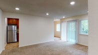 Located at 1833 Dahill Lane in Hayward, CA, this single-floor residence offers a thoughtfully organized layout with a neutral, move-in-ready aesthetic throughout. The living areas feature wall-to-wall carpeting in warm beige tones, complemented by textured ceilings and recessed lighting that create a comfortable, well-lit atmosphere. Large vertical-blind-covered sliding doors and windows allow generous natural light to filter into the main living spaces, with views of surrounding greenery adding a pleasant outdoor connection.

The kitchen is a functional highlight, featuring rich wood cabinetry, granite-style countertops, stone-look tile flooring, and a full suite of stainless steel appliances including a refrigerator, range, built-in microwave, and dishwasher. The layout maximizes counter and storage space efficiently.

Bedrooms are carpeted and bright, each with windows dressed in vertical blinds. The primary bedroom includes a walk-in closet and direct access to an en-suite bathroom. Bathrooms are finished with granite countertops, warm wood vanities, and stone-look tile flooring, with one featuring a tub-shower combination. A dedicated in-unit stacked washer and dryer adds everyday convenience.