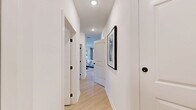 Located at 4010 Entrada Dr in Charlottesville, Virginia, this thoughtfully designed 2-bedroom, 2-bathroom residence offers a cohesive blend of modern style and everyday functionality across a single floor. Light wood flooring flows throughout, tying each space together seamlessly.

The kitchen is a standout feature, boasting crisp white shaker cabinets, stainless steel appliances, subway tile backsplash, open wood shelving, and a central island with seating — ideal for both cooking and casual dining. A door off the kitchen provides direct access to the outdoors, allowing natural light to fill the space.

The living area is bright and inviting, with large windows dressed in linen drapes and room for comfortable seating and entertainment. An additional flex space functions well as a home office, featuring corner windows that flood the room with natural light.

The primary bedroom is generously sized, featuring a ceiling fan, natural light from multiple windows, and a bold accent wall for visual interest. The second bedroom offers equal comfort and versatility. Both bathrooms are elegantly finished — one features a sleek walk-in glass shower, extended vanity with white countertops, and light wood flooring, while the second offers a clean, minimalist design. Two closets and recessed lighting throughout complete this refined Charlottesville residence.