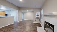 Located in Lenexa, Kansas, this single-floor, 2-bedroom, 3-bathroom home offers a functional and comfortable layout. The open living room is a standout space, featuring rich wood-style vinyl flooring, a white-mantled fireplace flanked by windows that invite natural light, and direct access to an exterior door. The kitchen is well-equipped with warm honey-toned wood cabinetry, light countertops, a stainless steel refrigerator, and matching appliances, offering ample storage and workspace in a classic U-shaped configuration. Both bedrooms feature plush carpeting, ceiling fans, and windows with outdoor views, creating a cozy and relaxing atmosphere. The primary bedroom includes a set of double closet doors leading to the main living area. Five closets throughout the home provide generous storage. The three bathrooms are clean and functional, featuring wood-toned vanity cabinetry, light countertops, mirrored medicine cabinets, and a tub-shower combination. Neutral wall tones and white trim carry consistently throughout the home, lending a cohesive and move-in-ready feel. The entryway area offers additional flexibility as a transitional space with its own exterior access.