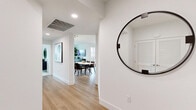 This well-designed single-floor residence in San Diego, CA offers three bedrooms, two bathrooms, and a thoughtfully organized layout that maximizes every square foot. The open-concept living area features light wood-style flooring, crisp white walls, and large windows that frame panoramic city and hillside views, filling the space with abundant natural light.

The kitchen is appointed with dark espresso cabinetry, white quartz countertops, stainless steel appliances including a gas range and French door refrigerator, a subway tile backsplash, and a center island with bar seating illuminated by pendant lighting — ideal for both meal preparation and casual dining.

The living room is bright and spacious, anchored by oversized windows offering sweeping outdoor views. The primary bedroom features plush carpet, floor-to-ceiling windows with city views, and dedicated closet space. Secondary bedrooms are equally well-lit, one featuring a teal accent wall and generous window exposure.

Both bathrooms are finished in a clean, modern aesthetic with full tub-shower combinations, white tile surrounds, brushed nickel fixtures, and wood-look flooring. The primary bath includes a dark wood floating vanity with an integrated sink. Three closets and two hallways complete the functional floor plan, offering ample storage throughout.