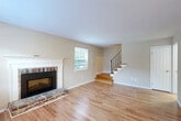 This two-bedroom, two-bathroom home in Prospect Park, PA is thoughtfully laid out across two floors of well-utilized living space. The main level features a welcoming living room highlighted by a classic brick fireplace with a white-painted wood mantel, gleaming hardwood floors, and a bright window that fills the room with natural light. A staircase with a sleek metal railing connects to the upper level. The adjacent dining room and kitchen are also found on the main floor, where the kitchen is equipped with stainless steel appliances — including a refrigerator, electric range, microwave, and dishwasher — complemented by light wood cabinetry and a white subway tile backsplash. A combined bathroom and laundry room on this level adds everyday convenience, housing a full-size top-load washer and dryer. Upstairs, two carpeted bedrooms offer a quiet retreat, each featuring multiple windows that bring in natural light and views of the surrounding neighborhood. The primary bedroom is generously proportioned with dual windows. A full bathroom on the upper level features tile flooring and a marble-surround shower. Four closets throughout the home provide ample storage. Neutral warm-toned walls and clean finishes create a cohesive, move-in ready atmosphere throughout.