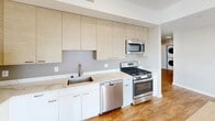 Located at Allure 1661 in Stamford, CT, this three-bedroom, two-bathroom residence offers a well-designed single-floor layout with a clean, contemporary aesthetic throughout. Wood-look flooring flows seamlessly across all rooms, complemented by neutral-toned walls and crisp white trim that create a bright, cohesive feel.

The open kitchen and living area serves as the heart of the home, featuring light wood cabinetry extending to the ceiling, quartz countertops, a stainless steel undermount sink, and a full suite of stainless steel appliances including a gas range, dishwasher, and over-the-range microwave. Floor-to-ceiling windows in the living area invite abundant natural light and frame sweeping views of the Stamford skyline and surrounding cityscape.

Three well-proportioned bedrooms provide flexible living arrangements. The primary bedroom includes a spacious closet with built-in shelving and hanging rods. Each bedroom benefits from natural light, with some offering city views. A dedicated closet with louvered doors adds additional storage.

The primary bathroom is finished with a floating vanity, sleek countertop, and a glass-enclosed walk-in shower. The second bathroom mirrors this modern style with a floating vanity and accessibility-friendly grab bars. Both bathrooms continue the wood-look flooring found throughout the residence, maintaining a unified design from room to room.
