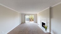 Located at 8218 Wooster Pike in Cincinnati, Ohio, this single-floor residence offers a well-organized layout with a range of functional living spaces. The living room is a standout area, featuring plush carpeting, crown molding, a textured ceiling, and a white-trimmed fireplace with a decorative tile surround. A sliding glass door floods the space with natural light and provides views of the surrounding greenery outdoors. The entryway transitions from warm hardwood-style flooring into the carpeted main living area, creating a welcoming flow throughout.

The kitchen is well-appointed with rich wood cabinetry, a white subway tile backsplash, hardwood-style flooring, and a full suite of black appliances including a refrigerator, electric range, and microwave. A window above the counter area brings in additional natural light.

The bedrooms are generously sized, each featuring soft carpeting and neutral wall tones. One bedroom includes a double closet setup offering ample storage, while additional windows provide natural light and ventilation. The bathrooms are finished with warm beige tile surrounding the tub and shower combinations, complemented by wood-toned vanity cabinetry and tile flooring, delivering a clean and practical aesthetic throughout.