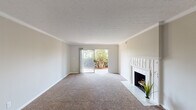 Located at 8218 Wooster Pike in Cincinnati, Ohio, this single-floor residence offers a well-organized layout with a range of functional living spaces. The living room is a standout area, featuring plush carpeting, crown molding, a textured ceiling, and a white-trimmed fireplace with a decorative tile surround. A sliding glass door floods the space with natural light and provides views of the surrounding greenery outdoors. The entryway transitions from warm hardwood-style flooring into the carpeted main living area, creating a welcoming flow throughout.

The kitchen is well-appointed with rich wood cabinetry, a white subway tile backsplash, hardwood-style flooring, and a full suite of black appliances including a refrigerator, electric range, and microwave. A window above the counter area brings in additional natural light.

The bedrooms are generously sized, each featuring soft carpeting and neutral wall tones. One bedroom includes a double closet setup offering ample storage, while additional windows provide natural light and ventilation. The bathrooms are finished with warm beige tile surrounding the tub and shower combinations, complemented by wood-toned vanity cabinetry and tile flooring, delivering a clean and practical aesthetic throughout.