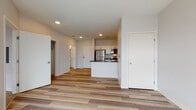 Located at 1450 Water St in Stevens Point, Wisconsin, this single-floor unit offers a clean, modern design with a thoughtfully arranged open-concept layout. The living area is bright and airy, featuring light-toned wood-style flooring and large windows that invite natural light and provide outdoor views of the surrounding landscape.

The kitchen is well-appointed with stainless steel appliances, including a full-size refrigerator, electric range, and built-in microwave. White cabinetry provides ample storage, while dark countertops add a contemporary contrast. A peninsula with a double-basin sink connects the kitchen to the living area, creating a functional and social space.

The bedroom features plush carpeting, soft neutral walls, and a window offering natural light and outdoor views. The bathroom is finished with wood-style flooring, white cabinetry with gold-toned hardware, a wide vanity with an integrated sink, and accessibility-friendly grab bars throughout.

Throughout the unit, recessed lighting, clean white walls, and consistent flooring choices contribute to a cohesive, modern aesthetic. The open flow between the living and kitchen areas makes the space feel expansive and versatile, well-suited for everyday living.