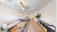 Located at 6925 Plentiful Springs Ct in Las Vegas, NV, this two-story home offers three bedrooms, five bathrooms, and a thoughtfully designed layout spread across two floors. The main level features an open-concept living, dining, and kitchen area bathed in natural light, with durable light wood-tone flooring flowing throughout. The kitchen is appointed with crisp white shaker cabinetry, quartz countertops, stainless steel appliances, and a large island with a deep undermount sink illuminated by pendant lighting above. The living area is bright and airy, anchored by a ceiling fan and large windows that bring in abundant natural light. A convenient half bathroom is also located on the main floor. Upstairs, the generously sized primary bedroom features plush carpeting, a ceiling fan, and a luxurious en-suite bathroom complete with a dual-sink vanity, white quartz countertops, and a glass-enclosed shower. Two additional carpeted bedrooms are found on the upper level, each with ceiling fans and windows with neighborhood views. Multiple closets provide ample storage throughout. The clean, neutral palette and modern finishes create a bright, cohesive ambiance across the entire home.