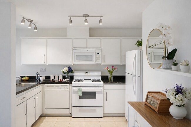 Cocina moderna con gabinetes blancos y electrodomésticos de tamaño completo. - 4401 Kraft Ave