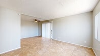 Located at 6575 W Ocotillo Rd in Glendale, Arizona, this two-story, 2-bedroom, 2-bathroom home offers a functional and comfortable layout spread across two floors. The ground floor features a welcoming entryway with tile flooring, a staircase leading to the upper level, and a living room equipped with a ceiling fan and sliding glass door that opens to an outdoor area, allowing natural light to fill the space. The galley-style kitchen is well-appointed with white cabinetry, granite-style countertops, stainless steel appliances including an electric range and refrigerator, and a ceiling fan overhead. Both bathrooms feature tile flooring and white vanities; one includes a full tub-shower combo, while the other offers a compact, efficient layout with a mirror and vanity. The two bedrooms are located on the upper floor, each with tile flooring, closets with sliding doors, and windows dressed with vertical blinds that bring in natural light. The primary bedroom includes direct access to a bathroom. Throughout the home, neutral gray walls, textured ceilings, and consistent tile flooring create a cohesive and clean aesthetic suited for everyday living.