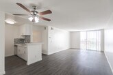 Located in the Silver Lake neighborhood of Los Angeles, this single-floor unit at 3630 Marathon Street offers a clean, modern living environment with a well-considered layout. The open-concept living area is finished with warm hardwood-style flooring and crisp white walls, creating a bright and airy atmosphere. A ceiling fan overhead provides both comfort and a subtle design accent. Large sliding glass doors with vertical blinds allow generous natural light to fill the living space while offering views of the surrounding neighborhood.

The kitchen is thoughtfully designed in a galley configuration, featuring white shaker-style cabinetry with brushed hardware, light stone countertops, and a striking mosaic tile backsplash with a blue-gray palette. Stainless steel appliances — including a gas range, refrigerator, and double-basin sink — complete the functional and stylish setup. A peninsula counter connects the kitchen to the main living area, providing additional workspace and a natural social divide.

The bathroom is finished with a white vanity, stone countertop, undermount sink, and a large mirror framed by overhead lighting, giving the space a clean and polished look. Throughout the unit, the consistent use of white tones and natural wood flooring creates a cohesive, contemporary aesthetic well-suited to modern urban living.