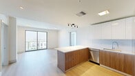 Located at 1740 S Young Circle in Hollywood, FL, this well-appointed 2-bedroom, 2-bathroom unit offers a clean, modern aesthetic with thoughtful design details throughout. Light wood-toned flooring flows seamlessly across the entire space, complementing the bright, neutral palette of the walls and ceilings.

The open-concept kitchen and living area serves as the heart of the home. The kitchen is outfitted with two-tone cabinetry — white upper cabinets paired with warm wood-finish lower cabinets — white quartz countertops, a tile backsplash, stainless steel appliances including a refrigerator, range, and dishwasher, and a peninsula that provides additional workspace and casual seating.

The generously sized primary bedroom features sliding glass doors that open to a balcony, framing expansive views of the Hollywood cityscape and surrounding greenery. The second bedroom also benefits from a large sliding glass door with similar scenic vistas. Both bedrooms are served by dedicated closets with wire shelving systems for organized storage.

The two bathrooms are finished in a clean, contemporary style with elongated tile surrounds in the tub/shower combinations, wood-toned vanity cabinetry, white quartz countertops, and backlit mirrors. Light wood-toned flooring continues throughout both bathrooms, maintaining a cohesive design. The overall ambiance is bright, airy, and move-in ready.