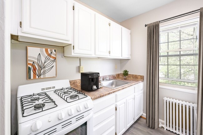 A white kitchen with a white stove and white cabinets. - Mason Hall