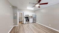 This 280 square foot studio apartment in Tucson, AZ offers a thoughtfully designed living space. The main area serves as a combined living room and bedroom, featuring wood-look flooring that adds warmth and durability. A modern ceiling fan with integrated lighting enhances air circulation and illumination, while a window-mounted air conditioning unit provides climate control.

The kitchenette, though compact, is equipped with white cabinetry and a full-sized refrigerator, offering ample storage and food preservation capabilities. Adjacent to the living area, it allows for easy meal preparation and dining.

The property boasts two bathrooms, an unusual luxury for a studio of this size. One bathroom showcases elegant marble-look tiling, creating a spa-like atmosphere. White fixtures and a combination tub-shower unit maximize functionality in the limited space.

A dedicated storage area with built-in shelving and hanging rods provides valuable organization options, essential in a studio layout. Large windows with horizontal blinds allow natural light to flood the space, creating an open and airy ambiance.

The neutral color palette, dominated by light grey walls and white trim, offers a blank canvas for personalization. This studio efficiently utilizes its limited square footage, providing a comfortable living environment in a convenient Tucson location.