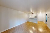 Located at 6351 Country Club Dr in Rohnert Park, CA, this one-bedroom, one-bathroom unit offers a well-organized single-floor layout designed for comfortable everyday living. The entrance opens into a bright hallway with light hardwood-style flooring that flows throughout the main living areas. The combined kitchen and living room serves as the heart of the unit, featuring an open, airy feel enhanced by a ceiling fan and a sliding glass door that leads to a private balcony overlooking the surrounding neighborhood. The kitchen is efficiently designed with white cabinetry, light countertops, a stainless steel gas range, a stainless steel refrigerator, and a built-in range hood — all positioned around a peninsula that separates the kitchen from the living area. A wall-mounted heater unit provides climate control in the living space. The bedroom is carpeted for comfort and features mirrored sliding closet doors that add depth to the room, along with additional closet storage accessible throughout the unit. The bathroom is clean and functional, equipped with a full tub-shower combination, a vanity with sink, and chrome fixtures. A dedicated hallway connects all areas of the unit, providing smooth circulation and privacy between the living and sleeping spaces.