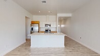 Located at 5602 Shadow Hills Rd in Las Cruces, NM, this single-story 2-bedroom, 1-bathroom home offers a clean, modern aesthetic throughout. Light wood-look tile flooring flows seamlessly across the entire home, complementing the crisp white walls and recessed lighting that create a bright, airy atmosphere.

The open-concept living, dining, and kitchen area serves as the heart of the home. The well-appointed kitchen features warm wood cabinetry, white upper cabinets, a large central island with a white quartz countertop and undermount sink, and a full suite of stainless steel appliances including a refrigerator with ice maker, range, microwave, and dishwasher.

The living area is bathed in natural light and opens to an outdoor space through a glass door, offering picturesque views of the surrounding Las Cruces landscape and mountains. Both bedrooms are comfortably sized, with the primary bedroom featuring generous closet storage. Each room benefits from natural light through well-placed windows with views of the open surroundings.

The full bathroom includes a soaking tub and shower combination with clean, neutral finishes. A dedicated laundry room houses a front-loading GE washer and dryer. Two hallways and additional closets provide practical storage throughout this well-designed home.