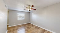 Located in El Paso, TX, this well-appointed 2-bedroom, 1-bathroom single-floor unit offers an efficient and comfortable layout. Wood-look laminate flooring runs consistently throughout the entire space, creating a cohesive and clean aesthetic from room to room. A bright hallway connects the main living areas, with natural light filtering through window blinds to keep the interior feeling open and airy.

The kitchen features white cabinetry, a mosaic tile backsplash, and ample counter space, flowing conveniently into a dedicated dining area. The living room provides a comfortable gathering space, while the adjoining dining room offers defined space for meals.

Both bedrooms are well-proportioned, each equipped with ceiling fans fitted with light kits for added comfort and illumination. Large windows dressed with horizontal blinds bring in natural light, and the rooms are complemented by neutral, textured walls. The unit offers an exceptional six closets total, providing generous storage throughout.

The bathroom is finished with large-format white marble-style wall tile surrounding the shower-tub combo, a white vanity with cabinet storage, wood-look tile flooring, and clean, minimal fixtures. Textured ceilings are present throughout the unit, and crisp white baseboards frame each room, adding a polished finishing touch to this practical and tidy El Paso residence.