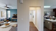 This two-floor residence offers a thoughtfully designed layout that balances functionality and comfort throughout. The kitchen is a standout feature, outfitted with sage-green cabinetry, white quartz countertops, stainless steel appliances including a gas range, microwave, and refrigerator, and a peninsula that provides additional prep and casual dining space. Wood-look flooring flows through the kitchen, hallways, and bathrooms, lending warmth and continuity to the home.

The living room is an inviting retreat, featuring plush carpet, a striking teal accent wall, and windows fitted with blinds that bring in natural light. The adjacent dining area is equally charming, with a classic chandelier overhead and direct access to a door leading outside.

The bedrooms are carpeted and fitted with sliding-door closets, offering ample storage. The full bathroom includes a tub-shower combination, a vanity with sage cabinetry, and rich hardwood-style flooring. A separate water closet provides added privacy and convenience. 

Completing the home is a dedicated in-unit laundry area with a full-size washer and dryer, along with overhead shelving for storage. Clean white walls, consistent trim work, and cohesive finishes throughout create a polished, move-in-ready atmosphere across both floors.