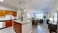 This well-appointed 2-bedroom, 2-bathroom residence in Stamford, CT offers a thoughtfully designed single-floor layout that maximizes comfort and functionality. The open-concept kitchen and living area serves as the heart of the home, featuring warm honey-toned cabinetry, stainless steel appliances, granite countertops, a center island with pendant lighting, and light wood-style flooring. Crown molding adds a refined touch throughout the main living spaces. The adjoining living and dining area is bright and welcoming, with large windows that invite natural light, and the living room opens to a comfortable, airy atmosphere ideal for relaxing or entertaining. The generously sized primary bedroom includes access to a walk-in closet and an en-suite bathroom, offering a private retreat. The second bedroom features soft carpeting and a sliding door that opens to an outdoor balcony with views of the surrounding greenery. Both bathrooms are finished with white tile flooring, tub-shower combinations, and clean white vanities. Two closets and a dedicated hallway provide ample storage throughout. The neutral color palette, quality finishes, and functional layout make this a highly livable space in a convenient Stamford location.