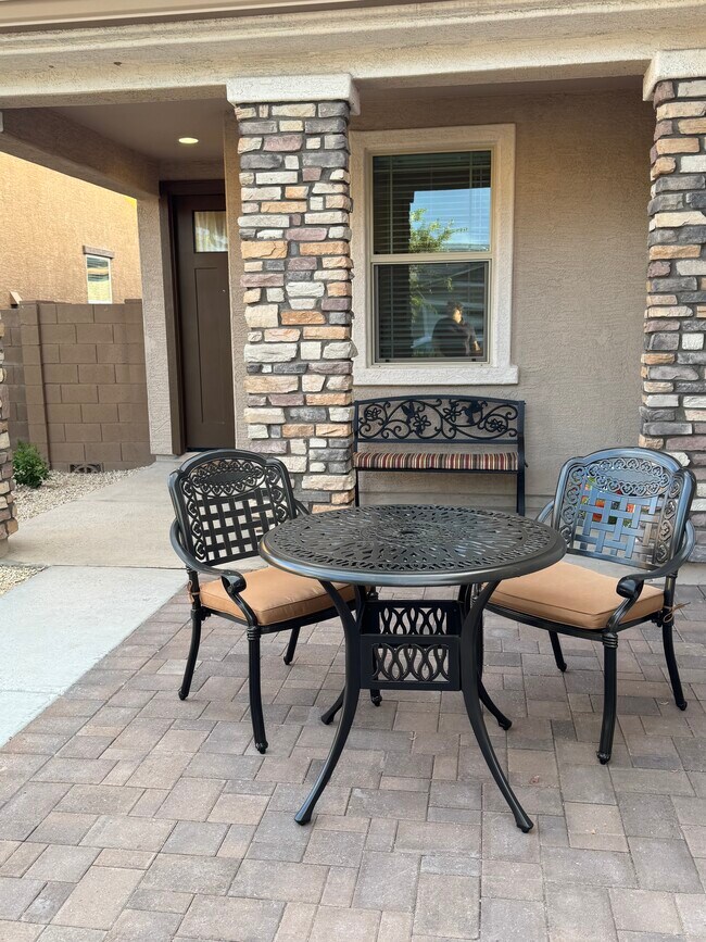 Porche delantero con mesa y sillas en el patio delantero. - 8957 W Palo Verde Dr