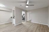 This efficiently designed single-story, one-bedroom, one-bathroom unit offers a bright and cohesive living experience throughout. The open-concept living room features light wood-look luxury vinyl plank flooring, neutral warm-gray walls, a textured ceiling, and a ceiling fan with integrated lighting. A sliding glass door floods the space with natural light while providing access to the outdoors. Adjacent to the living area is a dedicated closet space housing in-unit washer and dryer hookups, adding notable convenience.

The kitchen is separated from the living area by a pass-through countertop bar, offering a functional and social layout. White cabinetry, gray countertops, and a full suite of stainless steel appliances—including a refrigerator, microwave, and range—give the kitchen a clean, modern aesthetic.

The bedroom is a comfortable, well-proportioned retreat with matching vinyl plank flooring, a ceiling fan, and a mirrored sliding-door closet that maximizes storage. The bathroom features a tiled tub-shower combination, a white vanity with gray countertop, and coordinating hardware in brushed nickel. Two additional closets throughout the unit provide ample storage. The consistent finishes and neutral palette create a cohesive, move-in-ready atmosphere.