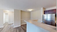 Located at 1701 Macon Rd in Perry, Georgia, this single-story home offers a practical and comfortable layout with four bedrooms, two full bathrooms, a living room, a hallway, and a utility room. The open-concept kitchen and living area form the heart of the home, featuring a peninsula-style breakfast bar, stainless steel refrigerator, and durable hardwood-style flooring that extends throughout the common areas. Neutral warm-toned walls and textured ceilings create a consistent and welcoming aesthetic. The living room is bright and airy, highlighted by a ceiling fan with light fixture and a set of French doors that invite natural light and provide outdoor access. Each of the four bedrooms is carpeted for added comfort and equipped with a ceiling fan. The bedrooms feature windows that bring in natural light and offer outdoor views, while closets provide convenient storage. The primary bedroom is a well-proportioned retreat with its own closet space. Both bathrooms are clean and functional, featuring tub-shower combinations with chrome fixtures, wood-toned vanity cabinetry, and hardwood-style flooring. A dedicated utility room adds practical functionality to the home's efficient and well-organized floor plan.