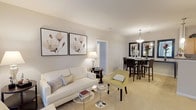 This contemporary apartment showcases a thoughtfully designed layout that maximizes space and functionality. The heart of the home is an open-concept living and dining area, adorned with elegant furnishings and tasteful artwork. The living room features a plush white sofa, complemented by a pale yellow accent chair and modern coffee tables. Large floral prints add a touch of sophistication to the space.

The adjacent dining area boasts a glass table with sleek chairs, while a console table with decorative vases adds visual interest. The kitchen is equipped with wooden cabinetry, black appliances, and ample counter space, perfect for culinary enthusiasts.

The bedrooms are havens of comfort, with one featuring a king-size bed adorned with a striking yellow headboard and crisp white linens. Another bedroom showcases a queen-size bed with a dark wooden frame and neutral bedding. Both rooms have windows allowing natural light to flood in.

The bathroom is functional and stylish, with a single vanity, large mirror, and a shower/tub combination. A separate laundry room with full-size washer and dryer adds convenience. The apartment also includes a walk-in closet with built-in shelving for organized storage.

Throughout the space, neutral tones create a calm ambiance, while carefully chosen accents add pops of color and personality. The overall design aesthetic is clean, modern, and inviting, perfect for contemporary living.