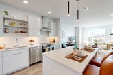 Located at 305 Winter St in Waltham, MA, this well-appointed 2-bedroom, 3-bathroom residence offers a thoughtfully designed single-floor layout that balances modern aesthetics with everyday functionality. The open-concept kitchen is a standout, featuring flat-panel white cabinetry, a classic subway tile backsplash, a full suite of stainless steel appliances including a gas range and dishwasher, and a generously sized island with quartz countertops illuminated by sleek pendant lighting — ideal for both cooking and casual dining. Light wood-tone flooring flows throughout the main living areas, adding warmth to the bright, neutral palette. Two distinct living areas provide flexible space for lounging and entertaining, each benefiting from abundant natural light through large windows. The spacious primary bedroom is a serene retreat highlighted by a wall of oversized windows framing panoramic city views, while the second bedroom is equally well-lit and comfortable. Three well-finished bathrooms include a glass-enclosed walk-in shower with white grid tile and a separate soaking tub with a decorative tile surround. The overall ambiance is clean, contemporary, and airy — a refined urban living experience in the heart of Waltham.
