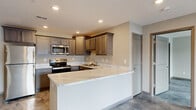 Located at 1812 Bourbon Street in Ashville, Ohio, this single-floor residence showcases a cohesive modern design highlighted by striking polished epoxy floors with a marble-like finish that flow seamlessly throughout the entire home. The open-concept kitchen is a standout feature, outfitted with gray raised-panel cabinetry, stainless steel appliances including a refrigerator, range, microwave, and dishwasher, and an expansive peninsula topped with elegant veined marble-style countertops — ideal for both meal preparation and casual dining. Recessed lighting illuminates the kitchen and living areas, creating a bright and welcoming atmosphere. The bedrooms are generously sized, with neutral wall tones, ceiling fans, and windows that invite natural light. A spacious walk-in closet with wire shelving provides ample storage. The bathrooms are well-appointed, each featuring a tub and shower combination, a single-sink vanity with white countertops, dark cabinetry, and large mirrors with overhead lighting. The consistent use of cool, neutral tones and polished surfaces throughout the home creates a clean, contemporary aesthetic that is both functional and visually cohesive.