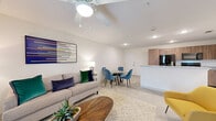 This thoughtfully designed 2-bedroom, 2-bathroom residence is laid out on a single floor, offering an efficient and comfortable living experience. The open-concept kitchen, dining, and living area forms the heart of the home, creating a seamless flow between spaces. The kitchen is equipped with warm wood-toned cabinetry, granite countertops, a peninsula with a built-in sink, and black stainless appliances including a range, microwave, and refrigerator. The adjacent living and dining area is bright and airy, featuring ceiling fans, recessed lighting, and a glass door that invites natural light and outdoor access. Both bathrooms are finished with elegant marble-style tile surrounds on the tub-shower combinations, paired with neutral flooring for a clean, modern aesthetic. Each bedroom is a comfortable retreat, complete with ceiling fans, carpeted floors, and natural light from windows. The primary bedroom includes its own closet and dedicated bathroom access. A hallway connects the private quarters to the shared living spaces, with two closets providing ample storage. The overall ambiance is modern and neutral, with clean lines and contemporary finishes throughout.