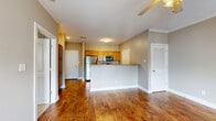 Located at 1317 Scottsville Rd in Bowling Green, Kentucky, this well-appointed one-bedroom, one-bathroom residence offers a thoughtfully designed single-level layout with a warm, neutral color palette throughout. Rich hardwood flooring flows through the main living areas, complemented by crown molding and ceiling fans that add a classic finishing touch.

The open-concept kitchen and living room form the heart of the home. The kitchen features warm wood cabinetry, stainless steel appliances including a refrigerator, microwave, and range, and a peninsula with a breakfast bar that separates the cooking area from the living space. The living room benefits from multiple windows with plantation shutters, allowing natural light to fill the room, and includes a dedicated entry door.

A built-in shelving and desk area provides a functional workspace or organizational nook just off the main living area, making practical use of every square foot. The spacious bedroom is finished with plush carpeting, a ceiling fan, a natural light-admitting window, and direct access to a walk-in closet. The bathroom offers a full tub-shower combination with clean white tile surround. A dedicated laundry area with washer/dryer hookups and overhead wire shelving adds everyday convenience to this efficiently designed home.