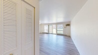 Located at 1400 Twombly Rd in DeKalb, IL, this one-bedroom, one-bathroom unit offers a practical and well-organized layout with clean, neutral finishes throughout. The living room serves as the heart of the space, featuring light hardwood-style flooring, bright white walls, and a ceiling fan overhead. Large windows and a sliding glass door flood the area with natural light while offering views of the surrounding greenery, creating an open and airy atmosphere. Baseboard heating runs along the exterior walls, complemented by a wall-mounted air conditioning unit for year-round comfort.

The bedroom is a comfortable, well-proportioned room with its own window providing natural light and outdoor views. A built-in closet with louvered bi-fold doors offers ample storage. The same light hardwood-style flooring carries throughout, maintaining a cohesive aesthetic across the unit.

The kitchen is efficiently laid out with dark cabinetry, a white range, and essential appliances. The bathroom features white subway tile walls, a pedestal-style sink, a mirrored medicine cabinet with vanity lighting, and a bathtub with shower, all finished with matching hardwood-style flooring. A dedicated entrance area completes the thoughtful layout of this well-maintained unit.