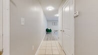 This single-floor, 2-bedroom, 2-bathroom home at 4501 Landing Drive in Orlando, Florida offers a well-organized layout with clean, modern finishes throughout. A tiled hallway serves as the central connector, leading from the entry to the living areas and bedrooms, with white panel doors and neutral walls contributing to a bright, cohesive feel.

The combined kitchen and living room area is a functional hub of the home. The kitchen features white shaker-style cabinetry, granite-look countertops, stainless steel appliances, a modern faucet, and light tile flooring — all finished with a window that brings in natural light. The adjacent living area transitions to wood-look luxury vinyl plank flooring and is filled with natural light from a large window and a sliding glass door that opens to lush, tree-lined outdoor views.

Both bedrooms feature the same wood-look flooring and windows overlooking the green surroundings, providing a calm and airy atmosphere. The primary bedroom offers a comfortable, well-proportioned footprint. The two bathrooms are finished with tile flooring, white vanities with granite-look countertops, and tub/shower combinations — one featuring a windowed surround with bright white tile. Textured ceilings are consistent throughout the home, adding a subtle classic touch to the overall design.