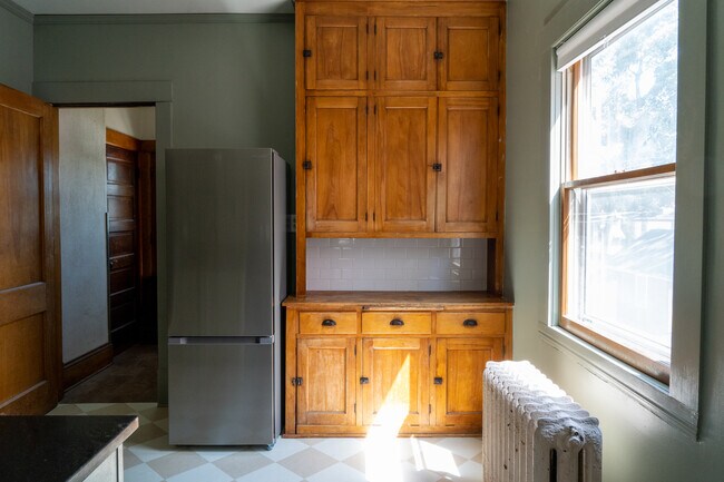 Kitchen w/ rear entry, new fridge and shaker cabinetry in view - 4031 Blaisdell Ave