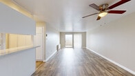 Located at 77 South Adams Street in Denver, CO, this one-bedroom, one-bathroom residence offers a well-organized and functional layout across a single floor. The open-concept living and kitchen area is anchored by warm wood-look flooring and neutral wall tones that create a bright, inviting atmosphere. A ceiling fan overhead and a sliding glass door leading to a private balcony enhance both comfort and natural light in the living space. The kitchen is thoughtfully designed with white cabinetry, stone-look countertops, a breakfast bar peninsula, and stainless steel appliances including a range and refrigerator, making it as practical as it is visually appealing. The bedroom is a comfortable retreat featuring plush carpeting, a full wall of louvered bi-fold closet doors providing generous storage, and a sliding glass door with outdoor access. The bathroom is clean and well-appointed, featuring wood-look flooring, a white vanity with stone-look countertops, a full mirror, and a separate tub/shower combination. Throughout the unit, consistent finishes and a cohesive neutral palette contribute to a polished, move-in-ready feel suited for comfortable Denver living.