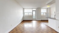 Located at 120 Raglan Ave in Toronto's sought-after Cedarvale neighbourhood, this 2-bedroom, 1-bathroom unit offers a well-organized single-floor layout with a clean, functional design throughout. Rich parquet hardwood flooring is a defining feature across the living, dining, and bedroom areas, adding warmth and character to the neutral white walls and bright interiors.

The spacious living room is bathed in natural light through large floor-to-ceiling windows with an access door to a balcony, framing open urban views of the surrounding Toronto skyline and neighbourhood rooftops. Baseboard heating runs along the perimeter of the main living spaces, ensuring comfort throughout the seasons.

The galley-style kitchen is efficiently designed with white cabinetry, subway tile backsplash, light tile flooring, dark countertops, and stainless steel appliances including a full-size refrigerator and dishwasher. The primary bedroom is generously proportioned, featuring a large window with city views, parquet flooring, and two closets — one walk-in and one standard. The second bedroom also benefits from natural light and parquet flooring, with a dedicated closet. The full bathroom includes a tub-shower combination, a single vanity, and tile flooring in a clean, all-white finish.