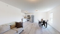 This single-floor, 2-bedroom, 2-bathroom home offers a thoughtfully designed layout that maximizes functionality and comfort. The open-concept main living area seamlessly connects the living room, dining area, and kitchen, creating a cohesive and inviting space. Light wood-style flooring flows throughout, complemented by crisp white walls that lend a clean, bright aesthetic.

The kitchen is a standout feature, equipped with white shaker-style cabinetry with matte black hardware, light marble-look countertops, a double stainless steel sink, and a full suite of stainless steel appliances including a refrigerator, electric range, microwave, and dishwasher. The dining area sits adjacent to the kitchen and benefits from natural light through a double-hung window with outdoor views.

The primary bedroom is a generously sized retreat with two closets and warm, neutral tones. The second bedroom is bright and airy, featuring a window with outdoor views and light flooring. Both bathrooms are finished in a clean, modern style with white vanity cabinetry, simple countertops, and tub-shower combinations. Throughout the home, the consistent use of light tones and low-maintenance finishes creates a cohesive, move-in-ready living environment.