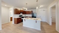 Located at 127 Madison St in Elyria, Ohio, this single-floor, 2-bedroom, 1-bathroom home offers a functional and thoughtfully designed layout. The kitchen is a standout feature, showcasing rich dark cherry cabinetry, white countertops, black appliances including a range and refrigerator, and a central island with pendant lighting and bar seating — ideal for both cooking and casual dining. Light wood-style flooring runs throughout the kitchen and main living areas, lending a clean, cohesive aesthetic.

Both bedrooms are carpeted and filled with natural light from windows overlooking the outdoors. The primary bedroom includes a dedicated walk-in closet with built-in shelving, while a secondary closet provides additional storage. The full bathroom features a shower-tub combo, modern fixtures, safety grab bars, and light wood-style flooring. A dedicated laundry room houses a full-size washer and dryer along with an overhead wire storage shelf and a water heater. Neutral wall tones and white trim throughout the home create a bright, inviting atmosphere suitable for a variety of living arrangements.