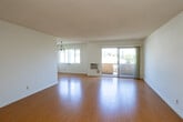 Located at 1025 S Holt Ave in the heart of Los Angeles, this single-story unit offers a well-organized layout with bright, open living spaces throughout. The living and dining areas are generously proportioned, showcasing warm hardwood-style flooring, crisp white walls, and a textured ceiling. A chandelier adds a refined touch to the dining area, while large sliding glass doors open directly onto a private balcony, inviting natural light and pleasant neighborhood views indoors. The living space also features a wall-mounted air conditioning unit for year-round comfort.

The kitchen is thoughtfully appointed with granite countertops, white cabinetry, and a full suite of stainless steel appliances, including a range, over-the-range microwave, and dishwasher. A window above the double-basin sink frames views of the surrounding neighborhood, enhancing the sense of openness.

The bedrooms continue the consistent hardwood-style flooring and feature ample closet space, including a spacious walk-in closet with built-in shelving and hanging rods, as well as additional reach-in closets with sliding doors. Each room is well-lit with natural light from large windows fitted with vertical blinds. The overall ambiance of the space is clean, functional, and move-in ready, making it an ideal setting in a prime Los Angeles location.