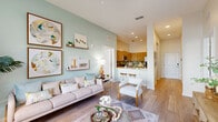 Located on International Drive in Orlando, Florida, this thoughtfully designed 2-bedroom, 3-bathroom residence offers a cohesive blend of modern aesthetics and functional living across a single floor. Light wood-style flooring flows throughout, tying together a bright and airy open-concept layout.

The living room serves as the heart of the home, showcasing sage green accent walls, tall ceilings, and floor-to-ceiling windows dressed in sheer white curtains that flood the space with natural light and offer outdoor views. The kitchen features warm wood cabinetry, a subway tile backsplash, stainless steel appliances, and a white quartz peninsula with bar seating — ideal for casual dining or entertaining.

A wide hallway connects the living areas to the private quarters, where two well-appointed bedrooms each offer distinct character. The primary bedroom is bathed in soft natural light through dual windows and includes a dedicated closet and a private en-suite bathroom with wood-toned vanity cabinetry and a glass-enclosed shower. The second bedroom makes a bold impression with a vibrant green accent wall and generous natural light. Three full bathrooms ensure comfort and convenience for residents and guests alike.