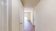 Located at 5316 Hull Street Road in Richmond, VA, this single-floor, 3-bedroom, 1-bathroom unit offers a practical and well-organized layout. Warm hardwood-style flooring runs consistently throughout the home, lending a cohesive and clean aesthetic to every room.

The combined living, dining, and kitchen area serves as the heart of the home. The living space is highlighted by a full-length sliding glass door that invites abundant natural light and provides a direct view of the surrounding greenery, creating a bright and open atmosphere.

A central hallway connects the three bedrooms, each featuring the same warm flooring and neutral, light-toned walls. The primary bedroom offers a comfortable footprint with a window that frames outdoor views. The additional bedrooms are similarly appointed, each with natural light from windows fitted with blinds. Notably, the home includes five closets distributed throughout, providing generous storage options.

The bathroom is clean and functional, featuring a full tub-shower combination, a vanity with dark cabinetry, and wood-look tile flooring that coordinates with the rest of the home. Central HVAC vents are present throughout the unit, ensuring climate control in every room. The overall design is simple, neutral, and move-in ready.