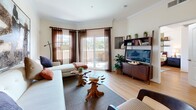 Located at 909 W Temple St in Los Angeles, this thoughtfully designed one-bedroom, one-bathroom residence offers a comfortable and stylish urban living experience across a single floor. The open-concept living and kitchen area serves as the heart of the home, where warm hardwood flooring, crown molding, and large sliding glass doors create a bright and inviting atmosphere. The living room features a generously sized sectional sofa, a unique live-edge coffee table, and direct access to a private balcony with pleasant outdoor views — ideal for relaxing or casual dining. The kitchen is efficiently laid out with rich wood cabinetry, dark granite countertops, stainless steel appliances including a gas range and refrigerator, and a peninsula with bar seating that connects seamlessly to the living space. The bedroom is a serene retreat, highlighted by a textured accent wall, floating display shelves, sheer curtains that allow ample natural light, and light hardwood flooring. A dedicated closet provides convenient storage. The bathroom is well-sized, featuring tile flooring, a wood-toned vanity with dark countertop, a framed mirror, and a full soaking tub with sliding glass enclosure. Every room reflects a cohesive, warm design sensibility suited for comfortable city living.