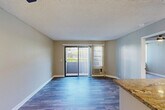 Located on El Cajon Boulevard in San Diego's College Area, this one-bedroom, one-bathroom residence offers a well-organized single-floor layout designed to maximize every square foot. The open-concept living, dining, and kitchen area forms the heart of the unit, where durable wood-style flooring, neutral toned walls, and a textured ceiling create a clean, functional atmosphere. A sliding glass door floods the living area with natural light and opens directly onto a private patio, offering a seamless indoor-outdoor connection. The kitchen is well-appointed with white shaker cabinetry, granite countertops, stainless steel appliances including a refrigerator, range with hood, and dishwasher, and a peninsula with a sink that doubles as a breakfast bar. The bedroom is a comfortable retreat featuring plush carpeting, a ceiling fan, a natural light window with vertical blinds, and ample closet space. The bathroom is finished with white cabinetry, granite countertops, wood-style flooring, and a full tub-shower combination. With four closets throughout, storage is a notable strength of this unit. The overall design is practical and move-in ready, well-suited for comfortable urban living in San Diego.