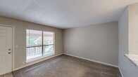 Located at 9421 E 65th St in Tulsa, Oklahoma, this one-bedroom, one-bathroom unit offers a well-organized single-floor layout designed for comfortable everyday living. The living room greets you with neutral-toned carpet, a textured ceiling, and a large window overlooking an outdoor balcony area, filling the space with natural light and views of the surrounding greenery. A ceiling fan with a light fixture adds practicality to this welcoming area. The kitchen is efficiently designed with light wood-look flooring, dark cabinetry, granite-style countertops, a stainless steel refrigerator, and direct access to a dedicated closet for additional storage. The bedroom is generously sized, featuring plush carpet, a ceiling fan, and a window that allows natural light to brighten the room. A standout feature is the French door access leading to the balcony, adding an airy, open feel. The bathroom is finished with a granite-topped vanity, a vessel sink, light wood-look tile flooring, and clean, neutral walls. Throughout the unit, warm beige tones, consistent flooring transitions, and ample natural light create a cohesive and inviting atmosphere.