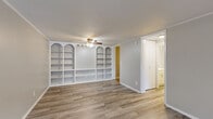 Located at 145 Newell St in Painesville, Ohio, this efficient one-bedroom, one-bathroom unit is thoughtfully laid out across a single floor. The combined dining and living area serves as the heart of the home, immediately drawing attention with its striking built-in shelving unit featuring arched detailing — an architectural accent that adds character and generous display or storage space. Light wood-style luxury vinyl flooring runs throughout the main living areas, complemented by crown molding, neutral tones, and a ceiling fan that contribute to a clean, cohesive aesthetic. The galley-style kitchen is well-equipped with white cabinetry, a granite-look countertop, a stainless steel sink, and white appliances, alongside a pantry for additional storage. The bedroom offers plush carpeting, a ceiling fan, natural light from a window, and ample closet access via two closets. The full bathroom is neatly appointed with a single vanity, white cabinetry, and a tub-shower combination. A hallway connects the spaces efficiently, and a unit-entry area with a window provides a welcoming transition into the home. Textured ceilings and consistent finishes throughout give the space a tidy, move-in-ready feel.