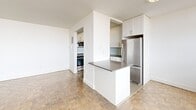 Located at 55 Triller Avenue in Toronto's vibrant Roncesvalles neighbourhood, this well-laid-out 2-bedroom, 1-bathroom unit offers a functional and comfortable living environment across a single floor. Classic parquet hardwood flooring flows throughout the main living areas and bedrooms, lending warmth and character to the space.

The open-concept layout connects the living room and dining room, creating a bright and spacious common area filled with natural light from large windows. The kitchen features white shaker-style cabinetry, a subway tile backsplash, dark countertops, stainless steel appliances including a dishwasher and refrigerator, and a peninsula that separates it from the living area—ideal for casual dining or meal prep.

Both bedrooms are generously proportioned, each benefiting from natural light through wide windows and baseboard heating. The primary bedroom includes mirrored sliding closet doors, while the second bedroom also features a closet. In total, the unit offers five closets, providing ample storage throughout.

The bathroom is finished with classic white subway tile surrounding a full soaking tub. Additional highlights include a dedicated entrance, a hallway, and access to a private balcony. The unit's clean, neutral palette and practical layout make it a versatile and move-in-ready home.